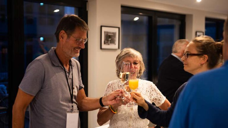 Menschen stoßen mit Sekt und Orangensaft an